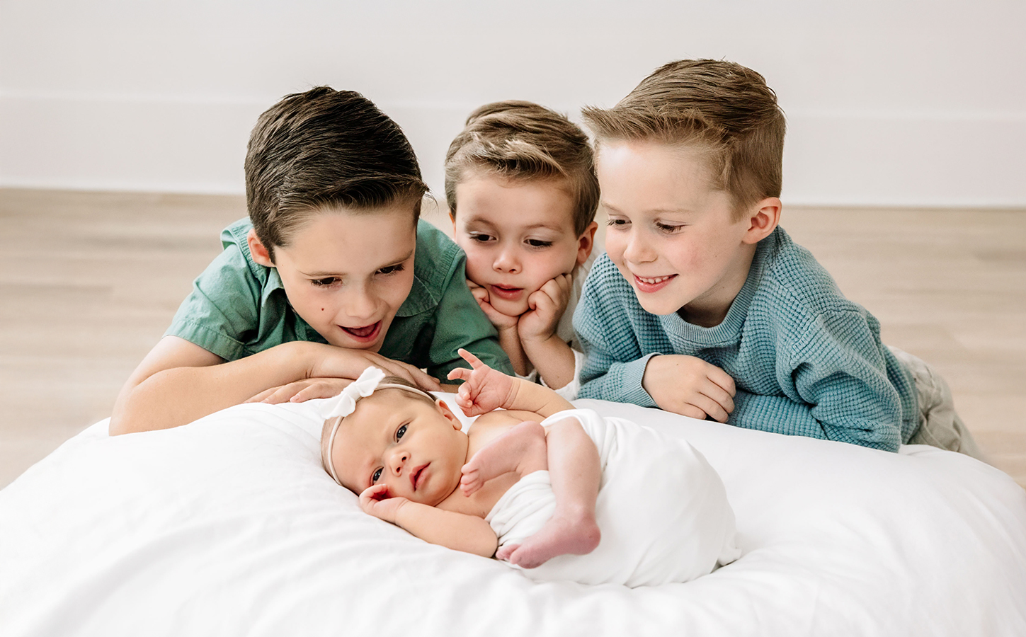 Young siblings at newborn photo session inn studio setting